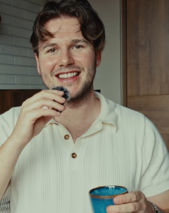 Sönke laughing with a coffee and a mic