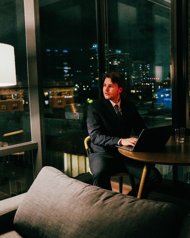 Sönke working on a laptop by a window at night