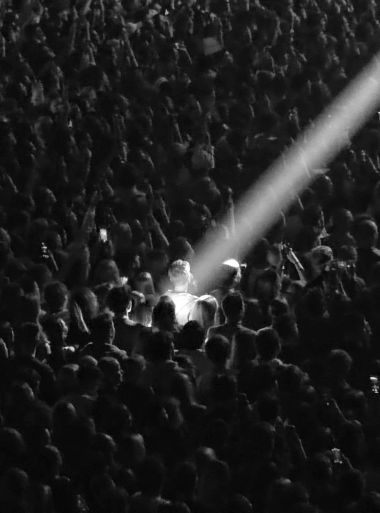 A spotlight picks out one person in a crowd